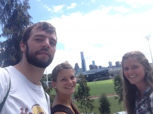 Da sind wir drei und im Hintergrund ist das Footballfeld &die Skyline von Melbourne